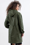 A person with curly hair wearing an OLIVE GREEN WINDBREAKER by The Windbreaker Jacket is seen from the back against a plain white background. The jacket has an adjustable hood, a gathered waist, and long sleeves. The individual is slightly turned to the right.